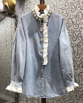 Denim shirt with lace details on a patterned wall background